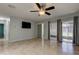 Spacious living room with tiled floors, ceiling fan, and sliding glass doors with dark curtains at 2380 Shelly Dr # B, Palm Harbor, FL 34684