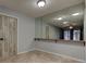 Room showcasing a large mirror, tile flooring, and a door with a unique wood-grain design at 2380 Shelly Dr # B, Palm Harbor, FL 34684