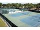Overhead view showcasing well-maintained tennis courts surrounded by lush greenery and protective fencing at 2380 Shelly Dr # B, Palm Harbor, FL 34684