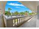 A serene balcony view showcases lush landscaping, blue skies, and the building's charming architectural design at 2461 Rhodesian Dr # 37, Clearwater, FL 33763