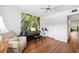 Bedroom featuring wood floors, ceiling fan, piano and nature-themed accent wall at 2461 Rhodesian Dr # 37, Clearwater, FL 33763
