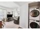 Living room featuring a television, stacked washer dryer, and dining area with fan at 2461 Rhodesian Dr # 37, Clearwater, FL 33763