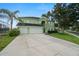 Home exterior with a three-car garage, mature palms, and green lawn at 2832 Brinley Dr, Trinity, FL 34655