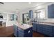 Kitchen island with blue cabinets, stainless sink, and backyard views at 2832 Brinley Dr, Trinity, FL 34655