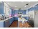 Kitchen boasts blue cabinets, an island, modern appliances, and ample counter space at 2832 Brinley Dr, Trinity, FL 34655