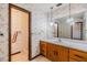 A stylish bathroom featuring floral wallpaper, a vanity with pendant lights, and a separate shower room at 309 Kenmore Rd, Brandon, FL 33511