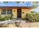 Inviting front entrance with a solid wood door, complemented by lush bushes and a concrete walkway at 309 Kenmore Rd, Brandon, FL 33511