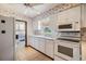 Well-lit kitchen featuring white cabinets, appliances, and a view into the laundry room at 309 Kenmore Rd, Brandon, FL 33511