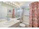 Bright bathroom with a single sink, a tub with shower and tropical patterned shower curtain at 3105 Avocet Pl, Safety Harbor, FL 34695