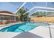 Stunning pool area featuring a screened enclosure, lush landscaping, and a soothing waterfall feature at 3105 Avocet Pl, Safety Harbor, FL 34695