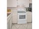 Bright kitchen featuring white appliances, neutral tile flooring, and plenty of cabinet storage space at 3126 Highlands Blvd # 3126, Palm Harbor, FL 34684