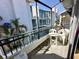 Private balcony with seating and views of the surrounding buildings and palm trees at 320 Medallion Blvd # G, Madeira Beach, FL 33708