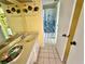 Cheerful bathroom featuring yellow walls, starfish decor, tile floors and a blue patterned shower curtain at 320 Medallion Blvd # G, Madeira Beach, FL 33708