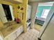 Compact bathroom with sink, washer, dryer, tile floors, and a peek into the bedroom at 320 Medallion Blvd # G, Madeira Beach, FL 33708