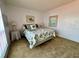 Inviting bedroom featuring sea themed decor, a comfortable bed, neutral carpet, and white walls at 320 Medallion Blvd # G, Madeira Beach, FL 33708