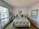 Airy bedroom showcasing a fish themed quilt and pillows, a large window, and white walls at 320 Medallion Blvd # G, Madeira Beach, FL 33708