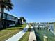 Scenic waterfront view with a paved walkway, boat docks, and lush green grass at 320 Medallion Blvd # G, Madeira Beach, FL 33708