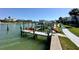 Picturesque waterfront view featuring private boat docks, lush landscaping, and clear blue skies at 320 Medallion Blvd # G, Madeira Beach, FL 33708
