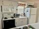 Bright kitchen features white appliances, ample cabinet space, and a window at 320 Medallion Blvd # G, Madeira Beach, FL 33708