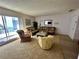 Comfortable living room with wicker furniture, sliding door to the balcony, and carpeted floor at 320 Medallion Blvd # G, Madeira Beach, FL 33708