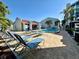Community pool with plenty of lounge chairs and lush landscaping offers a relaxing oasis at 320 Medallion Blvd # G, Madeira Beach, FL 33708