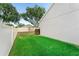 Green backyard with a swing set and a well-maintained lawn, enclosed by a white picket fence at 3406 Regner Dr, Plant City, FL 33566