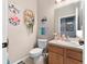 Cozy half bath with decorative wall art, wood vanity, and tile floors at 3406 Regner Dr, Plant City, FL 33566