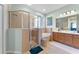 Bright bathroom with double sinks, large vanity, soaking tub, frameless glass shower and a separate standing mirror at 3406 Regner Dr, Plant City, FL 33566