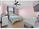 Bright bedroom with soft pink walls, large window, comfortable bed and functional workspace at 3406 Regner Dr, Plant City, FL 33566
