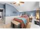 Bright bedroom with blue walls, a cozy bed with colorful pillows, and a charming decorative tree art piece at 3406 Regner Dr, Plant City, FL 33566
