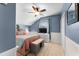 Comfortable bedroom featuring blue accent walls, a ceiling fan, and neutral-colored carpet at 3406 Regner Dr, Plant City, FL 33566