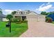 Beautiful home with a brick driveway, well-maintained lawn, lush landscaping, and a two-car garage at 3406 Regner Dr, Plant City, FL 33566