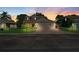 Charming home featuring a three-car garage, brick driveway, and well-manicured landscaping at dusk at 3406 Regner Dr, Plant City, FL 33566
