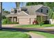 Charming home with a three-car garage, brick driveway, and lush green landscaping at 3406 Regner Dr, Plant City, FL 33566