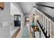Hallway featuring a staircase with black handrail and white spindles, with views into other rooms at 3406 Regner Dr, Plant City, FL 33566