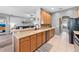 Open kitchen with tan countertops, wooden cabinetry, stainless steel appliances, and convenient breakfast bar at 3406 Regner Dr, Plant City, FL 33566