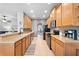 Spacious kitchen featuring wood cabinets, stainless appliances, tile backsplash and floors, and an eat-in breakfast bar at 3406 Regner Dr, Plant City, FL 33566