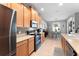Bright eat-in kitchen with stainless steel appliances, mosaic tile backsplash, tan countertops, and tile floors at 3406 Regner Dr, Plant City, FL 33566