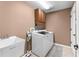 Practical laundry room with a washer, dryer, utility sink, and ample cabinet space for storage at 3406 Regner Dr, Plant City, FL 33566