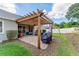 Inviting backyard patio with a wooden pergola, outdoor seating, and a grill, perfect for entertaining at 3406 Regner Dr, Plant City, FL 33566