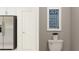 Convenient half bath features a sleek toilet, wall art, and a modern refrigerator, maximizing space efficiency at 3475 Silent Gardens Cv, Wesley Chapel, FL 33543