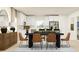 Modern dining room with a striking black table and stylish seating, seamlessly integrated with the kitchen at 3475 Silent Gardens Cv, Wesley Chapel, FL 33543