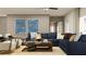 Spacious living room featuring modern furnishings, including a large sectional sofa and contemporary decor at 3475 Silent Gardens Cv, Wesley Chapel, FL 33543