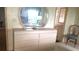 Light-filled bedroom with a dresser and mirror adjacent to the bathroom at 37648 Campo Ave, Zephyrhills, FL 33541