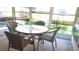 Enclosed sunroom featuring a glass table with seating for four, perfect for enjoying the outdoors indoors at 37648 Campo Ave, Zephyrhills, FL 33541