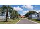 Charming street view with palm trees, leading to the community clubhouse and well-kept homes at 37648 Campo Ave, Zephyrhills, FL 33541