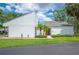Well-maintained white home with lush landscaping, palm trees, and a welcoming yellow front door at 4006 Cypress Lane #4006 # 4006, Tampa, FL 33618