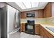 Functional kitchen boasts stainless steel refrigerator, black appliances, and plenty of cabinet space at 4006 Cypress Lane #4006 # 4006, Tampa, FL 33618