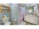 Split-image bathroom with a toilet and a sink and vanity with floral shower curtain at 402 S Armenia Ave # 139A, Tampa, FL 33609