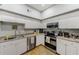 A well-lit kitchen featuring white cabinets and stainless steel appliances at 402 S Armenia Ave # 139A, Tampa, FL 33609